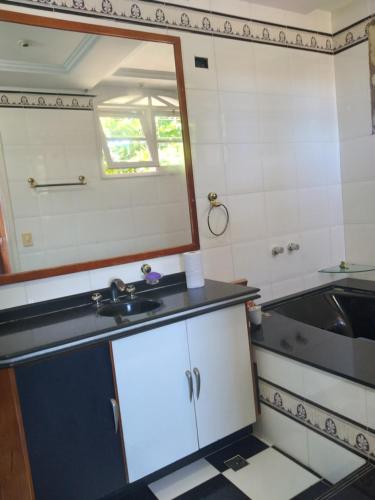 una piccola cucina con lavandino e specchio di Casa de novela , Sol e piscina a Cachoeiras de Macacu