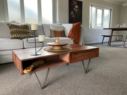 a living room with a couch and a coffee table at The Great Escape, Luxury Waterfront, HotTub in Whitianga