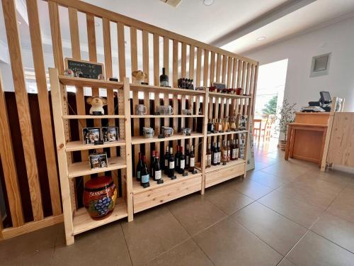 a wooden book shelf filled with bottles of wine at Vale do Zêzere Hotel in Manteigas