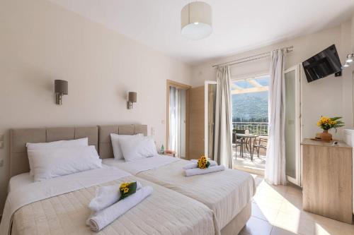 een slaapkamer met 2 bedden, handdoeken en een balkon bij Villa Miranda by Villa Plus in Ferendináta