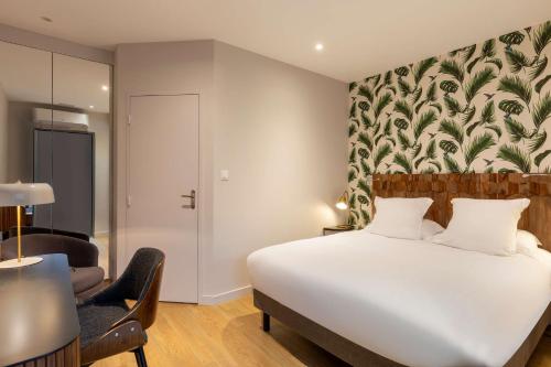 a bedroom with a large white bed and a chair at Best Western Plus d'Europe et d'Angleterre in Mâcon