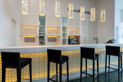 a bar with four black stools in a kitchen at Radisson Blu Resort & Thalasso Hammamet in Hammamet
