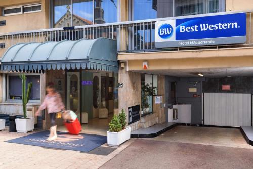 a man walking in front of a best western store at Best Western Hotel Mediterranee Menton in Menton