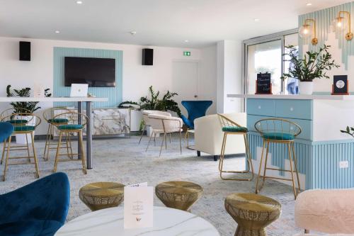 a living room with tables and chairs and a counter at Best Western Hotel Mediterranee Menton in Menton