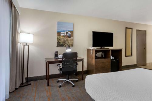 a hotel room with a bed and a desk and a television at Best Western Sunridge Inn & Conference Center in Baker City