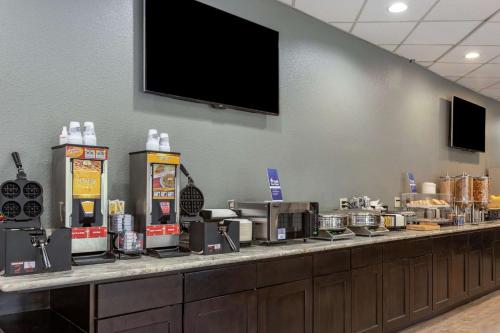 a buffet line with coffee machines and a tv on a wall at Best Western Sunridge Inn & Conference Center in Baker City