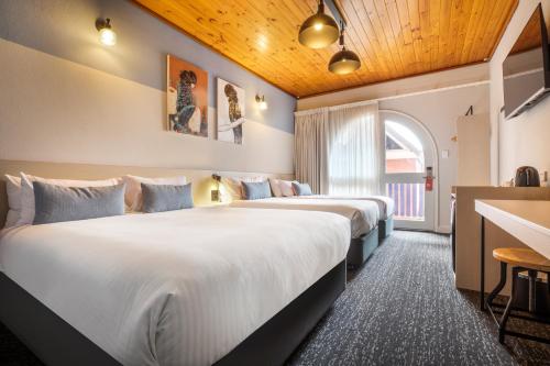 a hotel room with two beds and a window at Nightcap at Federal Hotel Mt Gambier in Mount Gambier