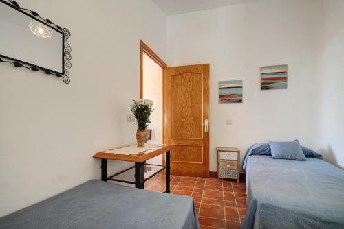 a bedroom with a bed and a table and a door at Casa Almoraima in Gaucín