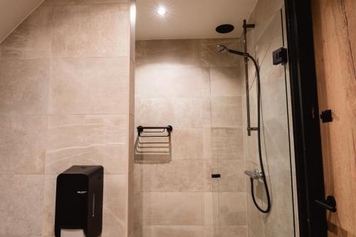 a bathroom with a shower with a glass door at Othmar Herberg in Ootmarsum