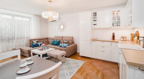 cocina y sala de estar con sofá y mesa en Apartament Marta Luxury, en Krynica Morska