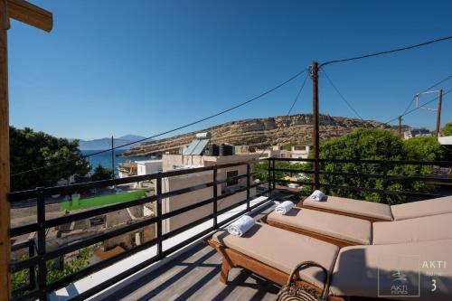 a balcony with lounge chairs and a view of a mountain at AKTI Homes Matala in Matala