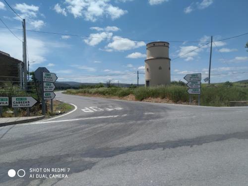 an empty road with a lighthouse in the background at CASITA AZUL MUÑICO , AVILA in Muñico