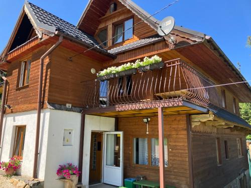 a house with a balcony with plants on it at Mała Bawaria in Zakopane