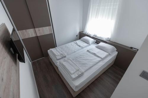 a small bedroom with a bed and a mirror at Hany Sweet in Niš