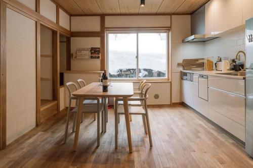 a kitchen with a table and chairs and a window at Nozawa Gondola Apartments in Nozawa Onsen