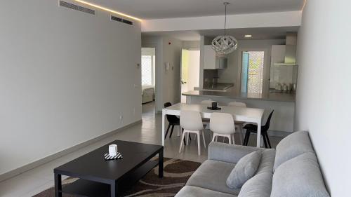 sala de estar y cocina con sofá y mesa en Lovely 2-Bedroom Holiday Home Higuerón Area, en Málaga