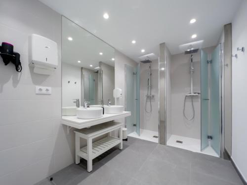 a white bathroom with a sink and a shower at Hostel Charino in Pontevedra