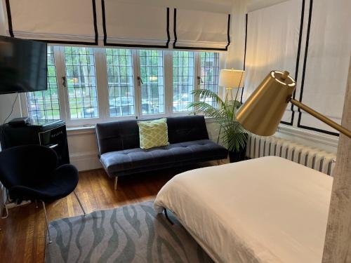 a bedroom with a bed and a couch and a window at The Jane Toronto in Toronto