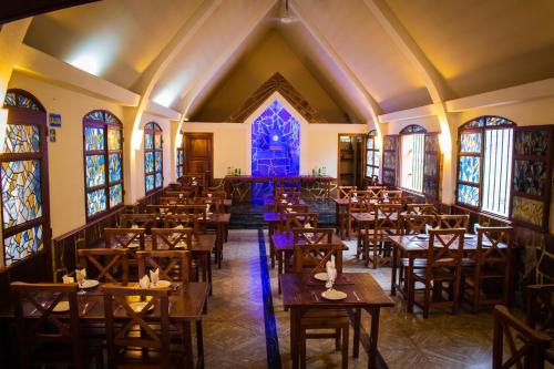 an empty dining room with tables and stained glass windows at Capilla del Lago in Villa Carlos Paz