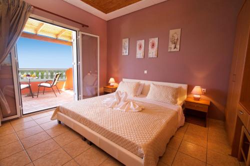 een slaapkamer met een bed en een balkon met uitzicht bij Villa Marina Epavlis by Villa Plus in Karavomylos