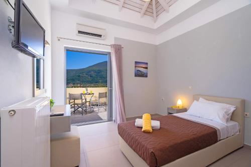 a bedroom with a bed with a view of a patio at Villa Rubi by Villa Plus in Karavomylos