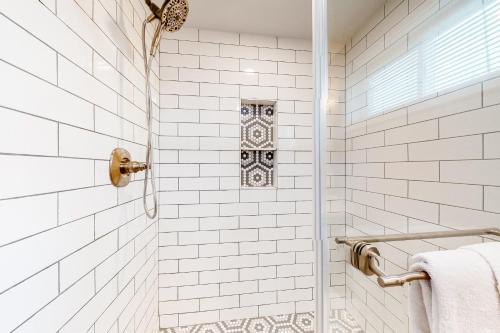 y baño con ducha y azulejos blancos. en Montego Bay-Bayside Blues on Beachcomber, en Ocean City