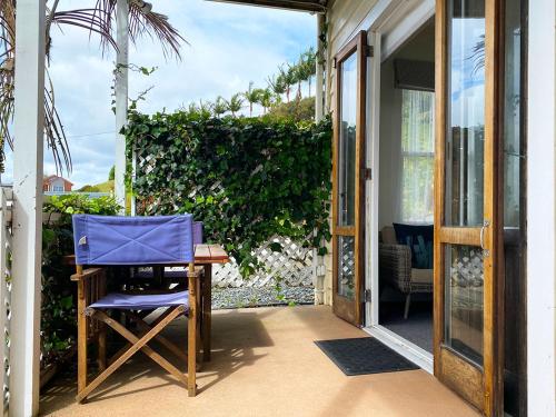 a blue chair sitting on the porch of a house at Mangonui Waterfront Apartments in Mangonui
