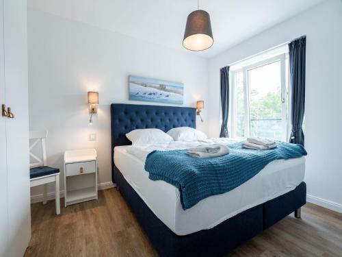 ein Schlafzimmer mit großem Bett und Fenster in der Unterkunft Dünenresidenz Prora - Ferienwohnung mit 2 Schlafzimmern und Balkon B3-2-3 in Binz