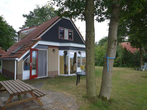 ein kleines Haus mit einem Picknicktisch und einem Baum in der Unterkunft Restful Holiday Home in Lemele with a Spacious Garden in Lemele