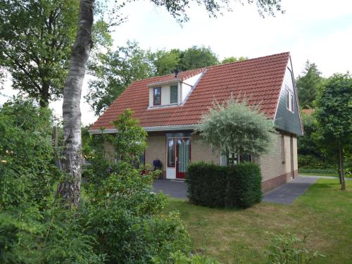 uma pequena casa com um telhado vermelho em Fine vacation home near Lemelerberg em Lemele