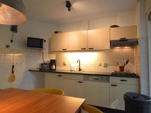 uma cozinha com armários brancos e uma mesa de madeira em Tranquil Holiday Home in Lemele with Terrace em Lemele