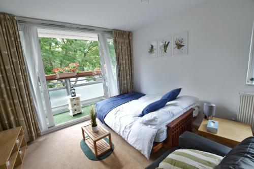 a bedroom with a bed and a large window at Garden Tower flat in London