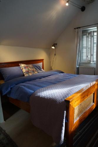 a bedroom with a bed with blue sheets and a window at Studio Rempart in Brussels