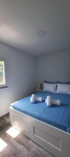 a bedroom with a large blue bed with two pillows at Atlantico in Geres