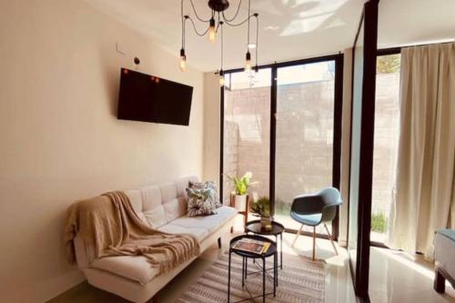 a living room with a couch and a chair at Departamento a una cuadra de la playa by G P S rentas in Mazatlán