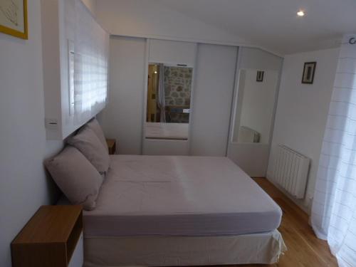 une petite chambre avec un lit et un canapé dans l'établissement Maison avec Piscine Chauffée, Jardin, WIFI, Proche Plages et Commodités à Erdeven - FR-1-397-53, à Erdeven