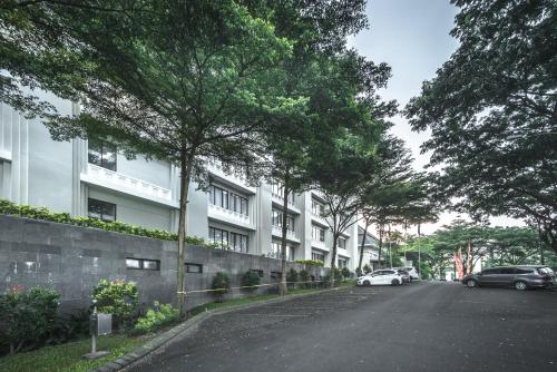 a street with cars parked in front of a building at HARRIS Hotel & Conventions Malang in Malang