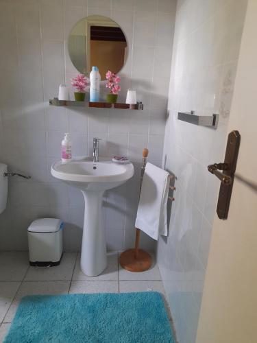 un bagno bianco con lavandino e specchio di Maison ROSE CAYENNE a Saint-François
