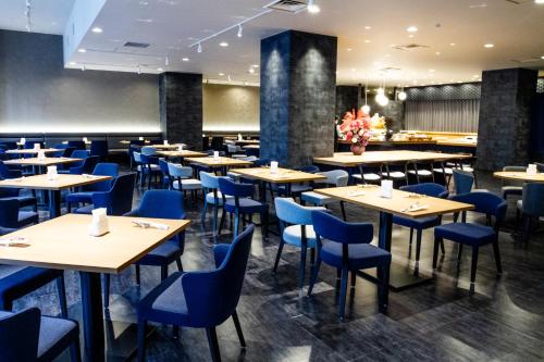 een eetkamer met tafels en blauwe stoelen bij Hotel Kanazawa in Kanazawa