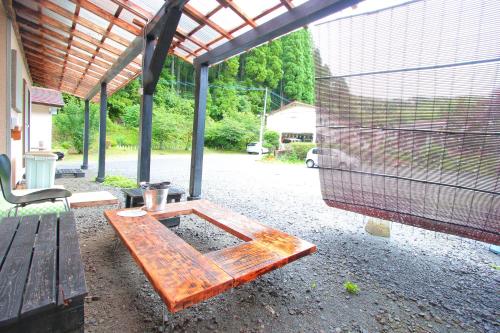 a wooden bench sitting on the ground next to a cage at Ramune Onsen Senju no Sato in Kirishima