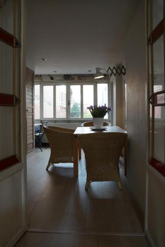 a dining room with a table and chairs and a window at Studio Rempart in Brussels