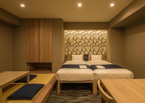 a hotel room with two beds and a table at KOKO HOTEL Residence Asakusa Kappabashi in Tokyo