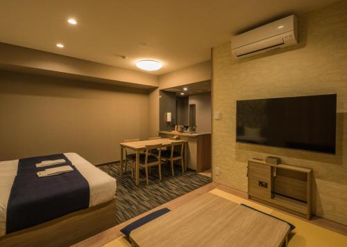 a hotel room with a bed and a flat screen tv at KOKO HOTEL Residence Asakusa Kappabashi in Tokyo