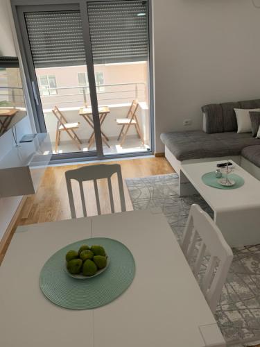 uma sala de estar com uma mesa com uma taça de fruta em Apartman A2 em Ulcinj