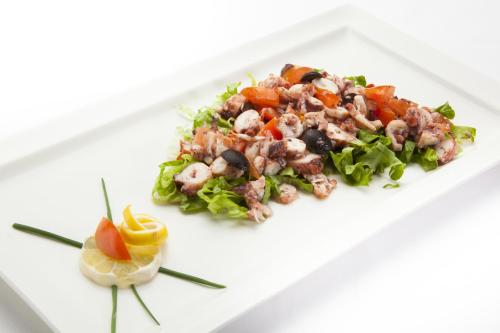 a plate of food with a salad on a white plate at Hotel Lungomare Opatija - Liburnia in Opatija