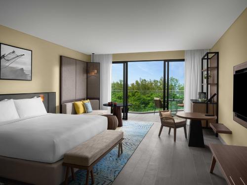 a hotel room with a bed and a living room at Crowne Plaza Phu Quoc Starbay by IHG in Phu Quoc