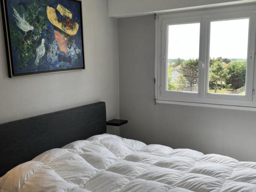 une chambre avec un lit blanc et une fenêtre dans l'établissement Appartement 2 pièces avec balcon, ascenseur, cuisine équipée - Cabourg - FR-1-487-340, à Cabourg