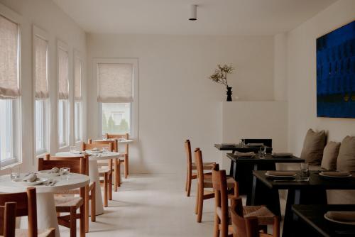 a dining room with tables and chairs and aearcher at The James Bradley in Bradley Beach