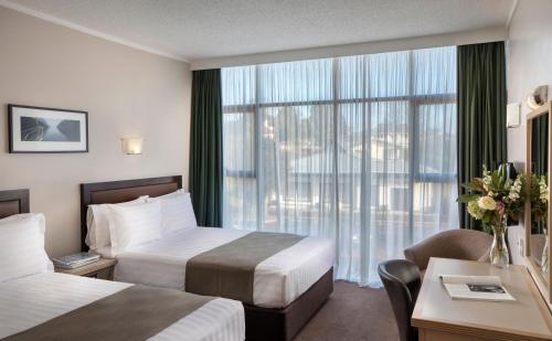 um quarto de hotel com duas camas e uma janela em Rydges Rotorua em Rotorua