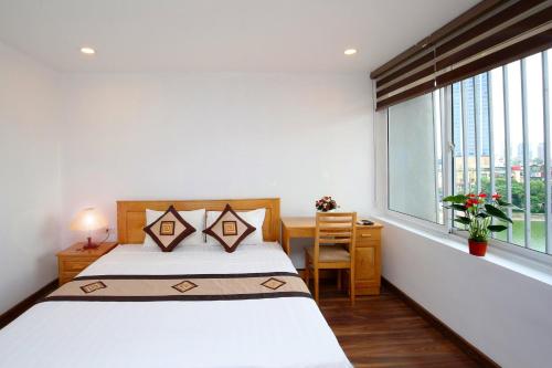 a bedroom with a bed and a desk and a window at Sumitomo luxury apartment hotel near Lotte in Hanoi